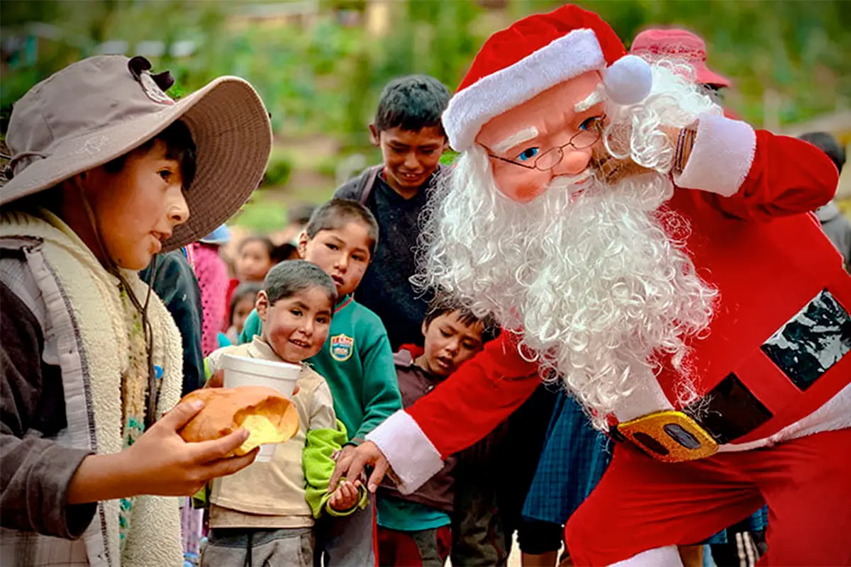 Santa Claus celebrando la Navidad junto a niños andinos, una escena de alegría y tradición en las comunidades rurales de Perú.
